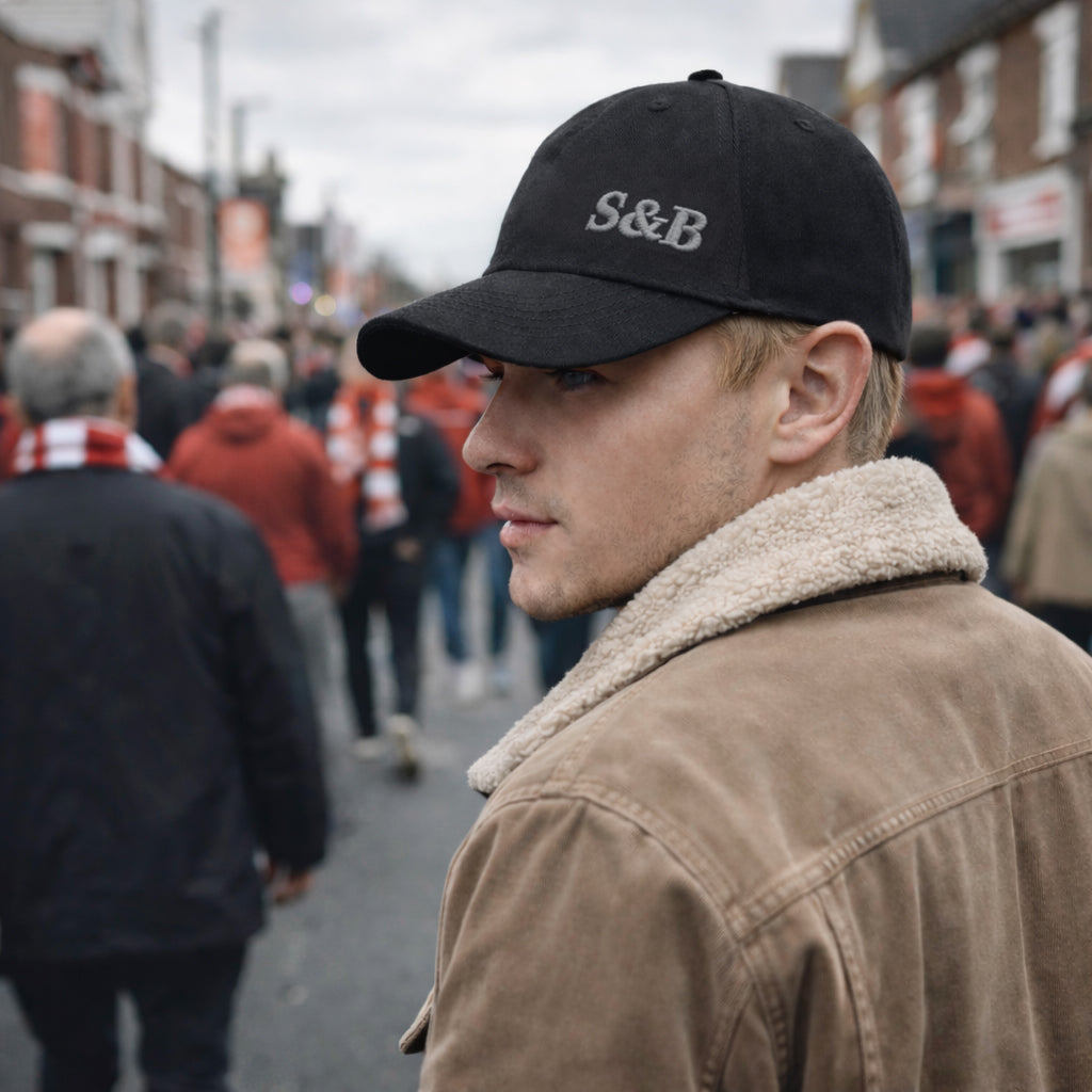 Model wearing Away Days Cap in black in urban street setting by Sauce & Brown