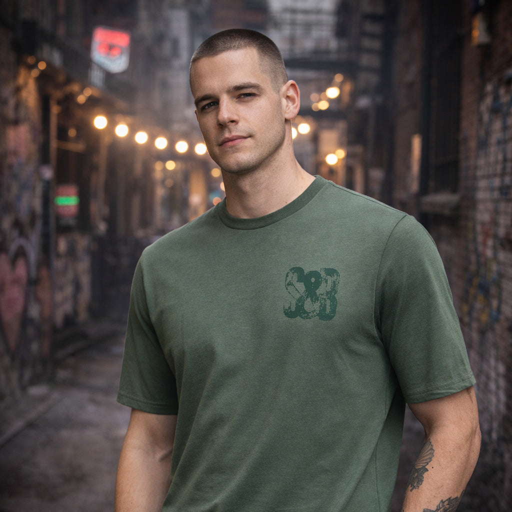 Model wearing Green Bay T-Shirt in green outdoors by Sauce & Brown