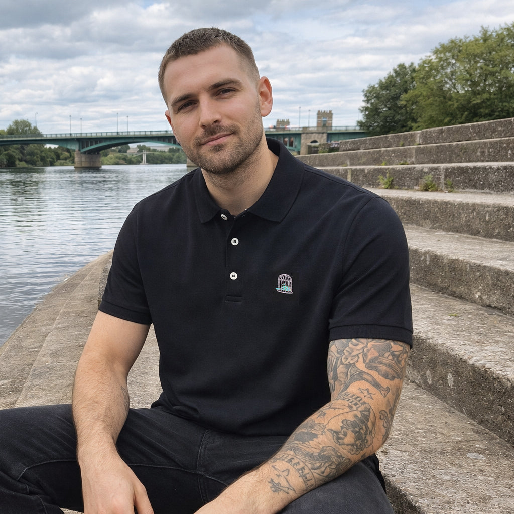 Sauce & Brown Coaled Polo in black worn by model sitting outdoors lifestyle view