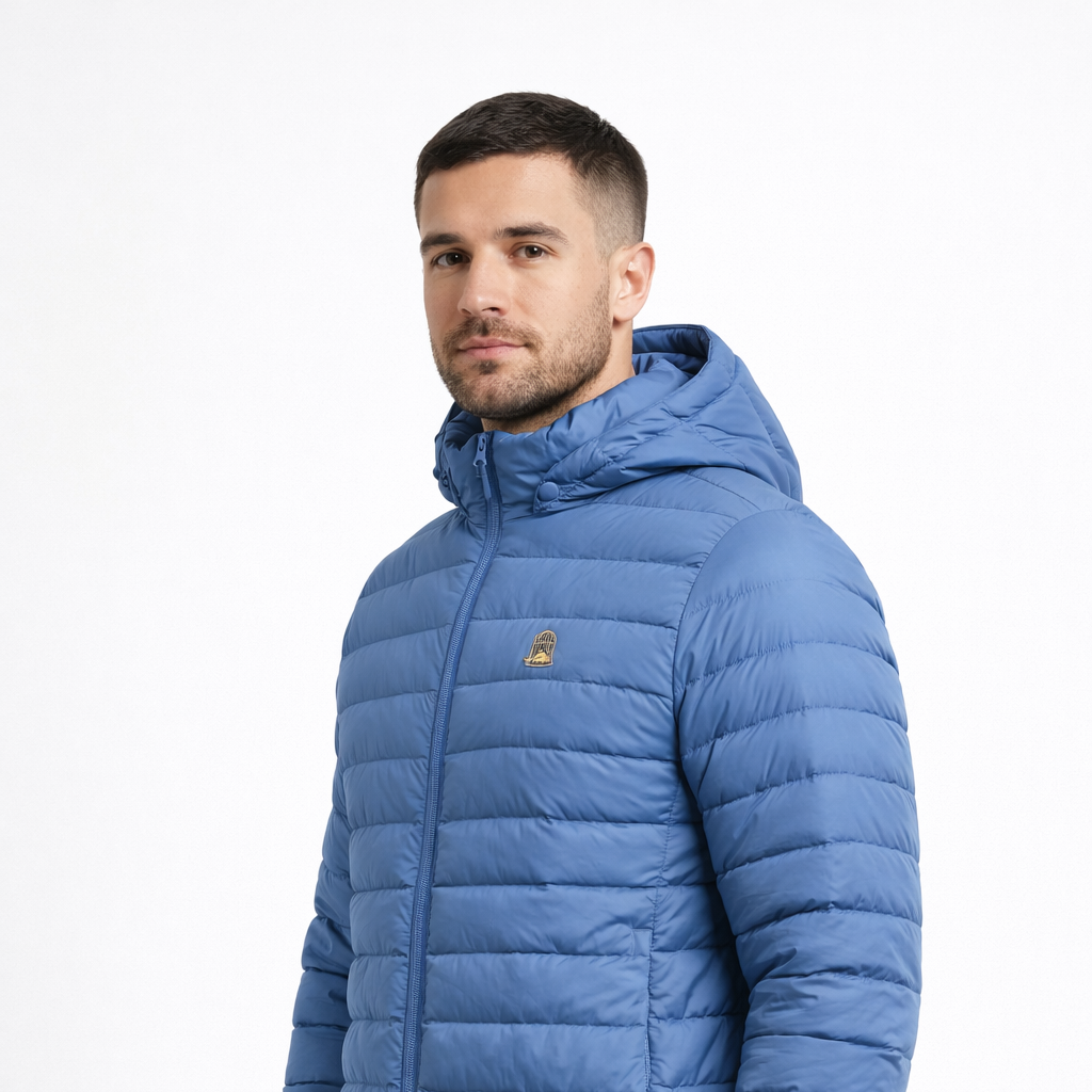 Angled view of Liberty Jacket in blue with chest logo worn by model by Sauce & Brown